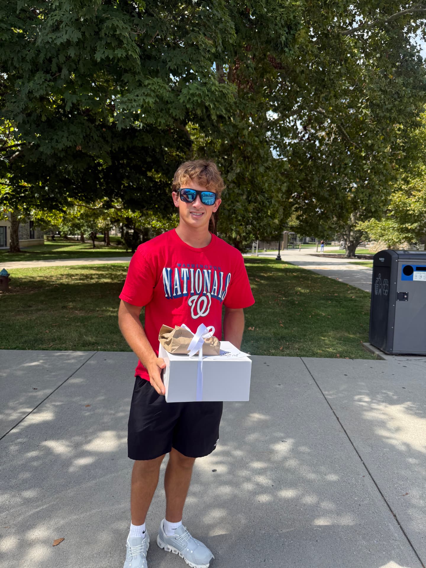 A student holding a bakery gift box on campus